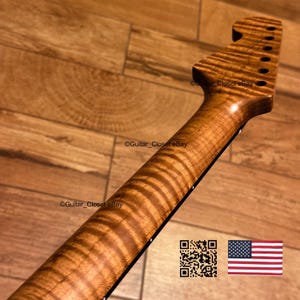 Op de afbeelding: Een gitaarhals met een opvallend tijgerstreep-patroon in het gevlamde esdoornhout met een natuurlijke amberkleurige afwerking. De kop bevat zes stemmechaniekgaten op een rij. De tekst Guitar_Closet eBay is zichtbaar op de afbeelding.