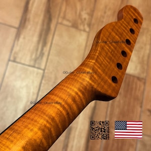 May include: A guitar neck with a flamed maple finish. The wood grain has a wavy pattern with a golden-brown color. The headstock has six tuning peg holes. The image includes a QR code and the American flag.