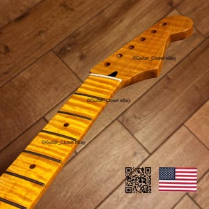May include: A maple guitar neck with a flamed grain pattern. The headstock has tuning peg holes. The fretboard has black fret markers. The image includes a QR code and the American flag.