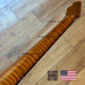 May include: A close-up of a guitar neck with a flamed maple finish. The neck is a warm, amber color with a striped pattern. The fretboard is black with white dot inlays. The text "Guitar_Closet eBay" is visible.