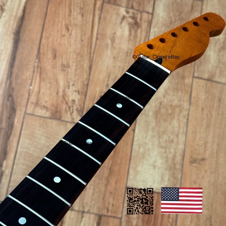 以下が含まれることがあります： 暗い指板と白いインレイが付いたギターネック。ヘッドストックは、チューニングペグ用の穴がある明るい木の色です。ネックはヴィンテージルックです。画像にはQRコードとアメリカ国旗も含まれています。