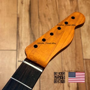 May include: A guitar neck with a light brown headstock and a dark brown fretboard. The headstock has six black tuning peg holes. The fretboard has silver frets. The text "Guitar_Closet eBay" is visible on the headstock. A QR code and American flag are in the image.