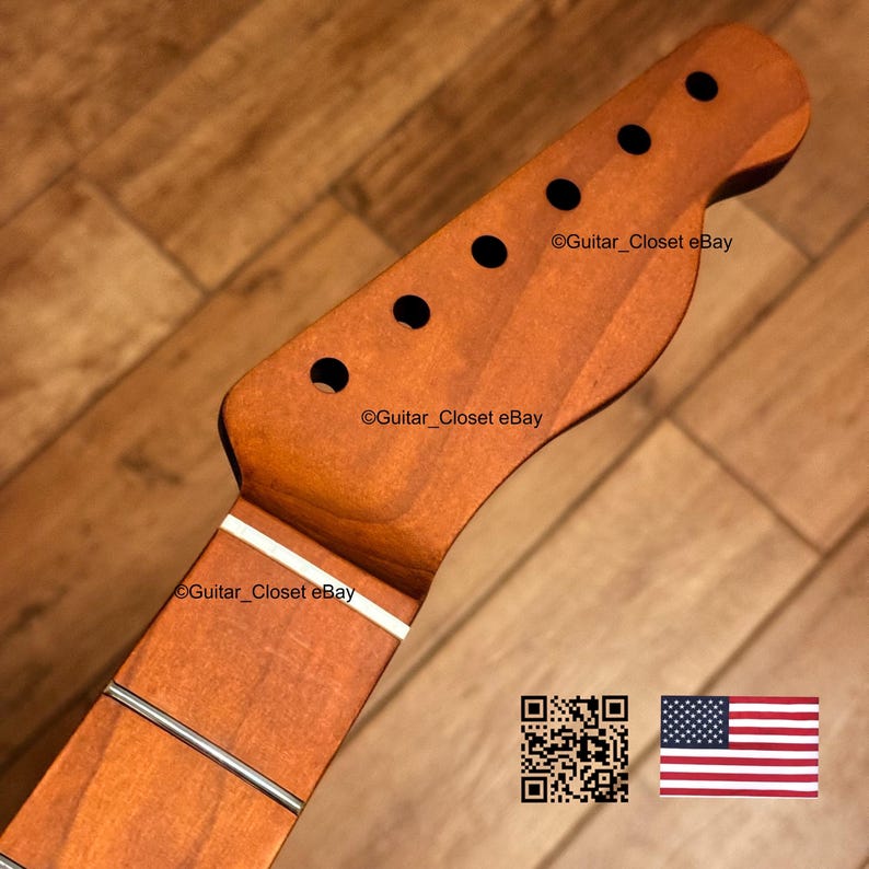 K&ouml;nnte beinhalten: Ein h&ouml;lzerner Gitarrenhals mit sechs Stimmwirbell&ouml;chern und einem Griffbrett mit Metallb&uuml;nden. Der Hals hat eine warme braune Farbe mit einem wei&szlig;en Streifen. Der Text "Guitar_Closet eBay" ist sichtbar. Eine amerikanische Flagge ist im Bild.