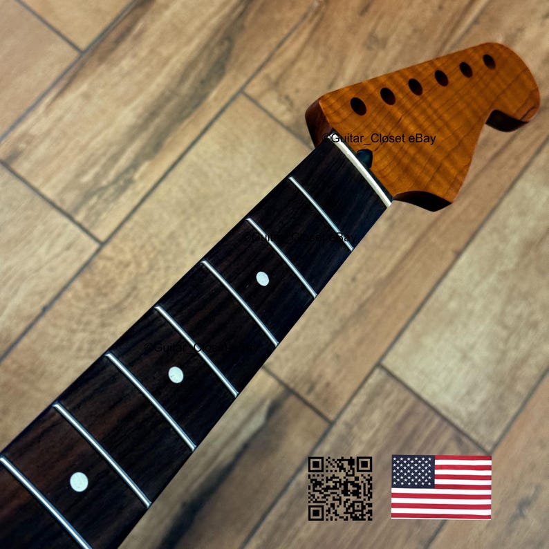 May include: A guitar neck with a dark brown fretboard and a light brown headstock. The fretboard has white inlays and frets. The headstock has six tuning peg holes. The text "Guitar Closet eBay" is visible. An American flag is in the bottom right corner.