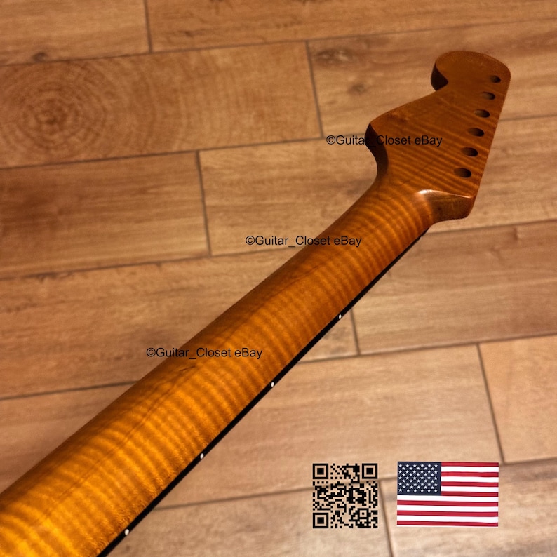 May include: A guitar neck with a flamed maple finish. The neck is a light brown color with a wavy grain pattern. The headstock has tuning peg holes. The image also includes a QR code and the American flag.