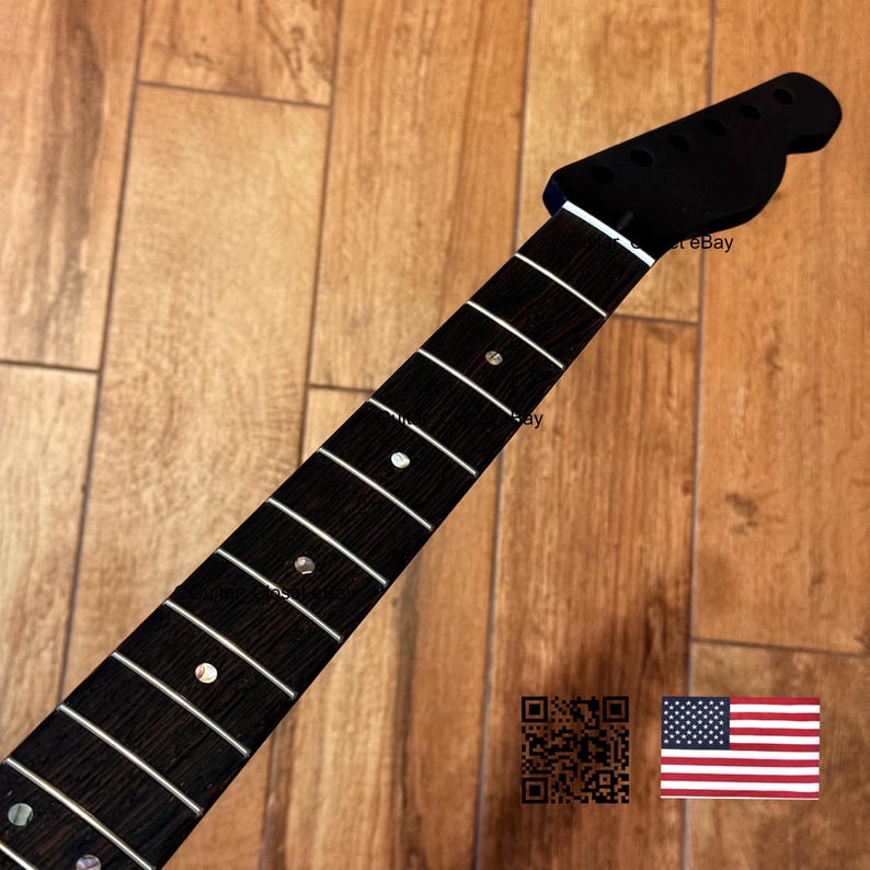 May include: A black guitar neck with white frets and dot inlays. The headstock is also black. The neck is set against a wooden background. The image includes a QR code and an American flag.