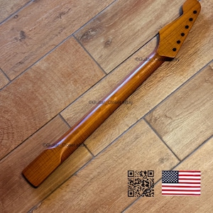 May include: A wooden guitar neck with a natural finish. The neck has a headstock with tuning peg holes and a smooth, polished surface. The image includes a QR code and a small American flag.