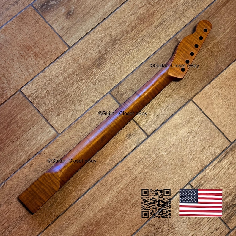 May include: A wooden guitar neck with a natural finish. The neck has a headstock with tuning peg holes and a smooth, polished surface. The wood grain is visible, and the neck is angled. The image includes a QR code and an American flag.