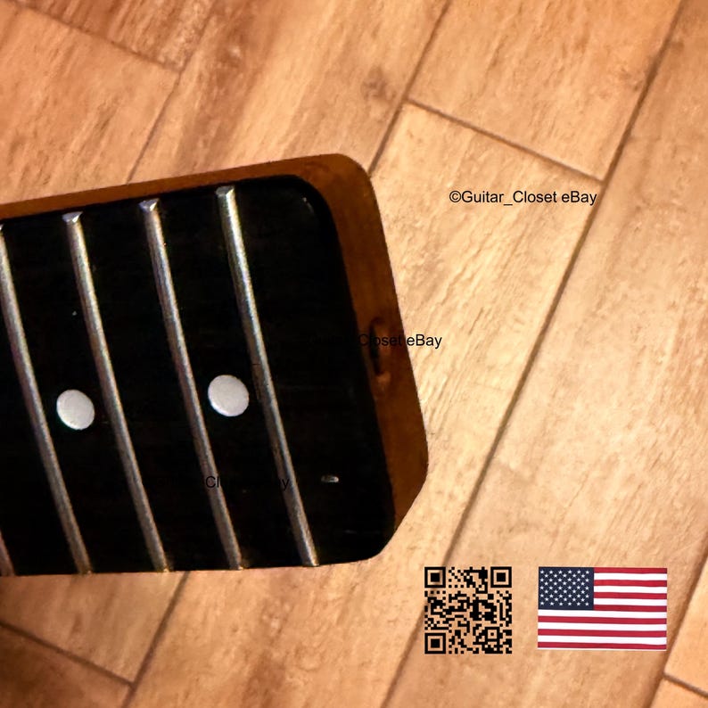 Op de afbeelding: Close-up van een gitaarhals met een donkere toets en zilveren frets. Twee witte fretmarkers zijn zichtbaar. Het hout heeft een warme, bruine tint. De afbeelding bevat de tekst "Guitar_Closet eBay", een QR-code en de Amerikaanse vlag.