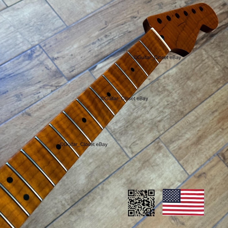Puede incluir: M&aacute;stil de guitarra con diapas&oacute;n y pala de arce flameado. El m&aacute;stil tiene trastes plateados y marcadores de traste negros. La pala tiene agujeros para las clavijas. La imagen incluye un c&oacute;digo QR y la bandera estadounidense.