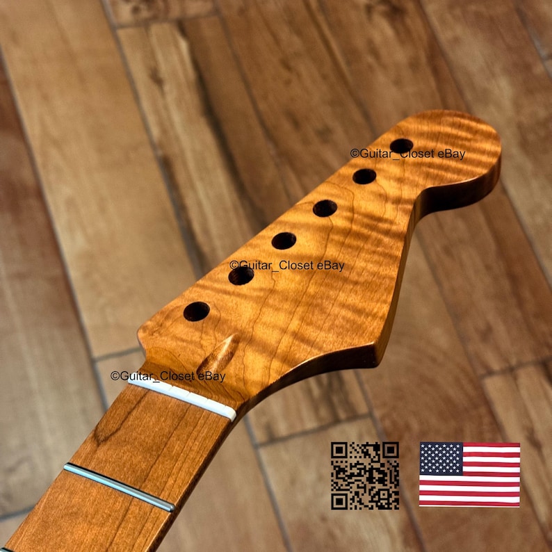 May include: A guitar neck with a flamed maple headstock. The headstock has six tuning peg holes and a natural wood finish. The fretboard is a lighter colour with two silver frets. The text "Guitar_Closet eBay" is visible on the headstock.