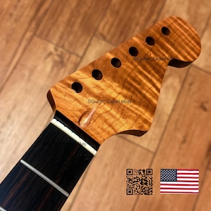 Może przedstawiać: Gryf gitarowy z jasnobrązową gł&oacute;wką z klonu płomienistego z sześcioma otworami na klucze oraz ciemnobrązową podstrunnicą z palisandru z białym siodełkiem. Na gł&oacute;wce widnieje napis Guitar_Closet eBay, kod QR oraz flaga Stan&oacute;w Zjednoczonych.