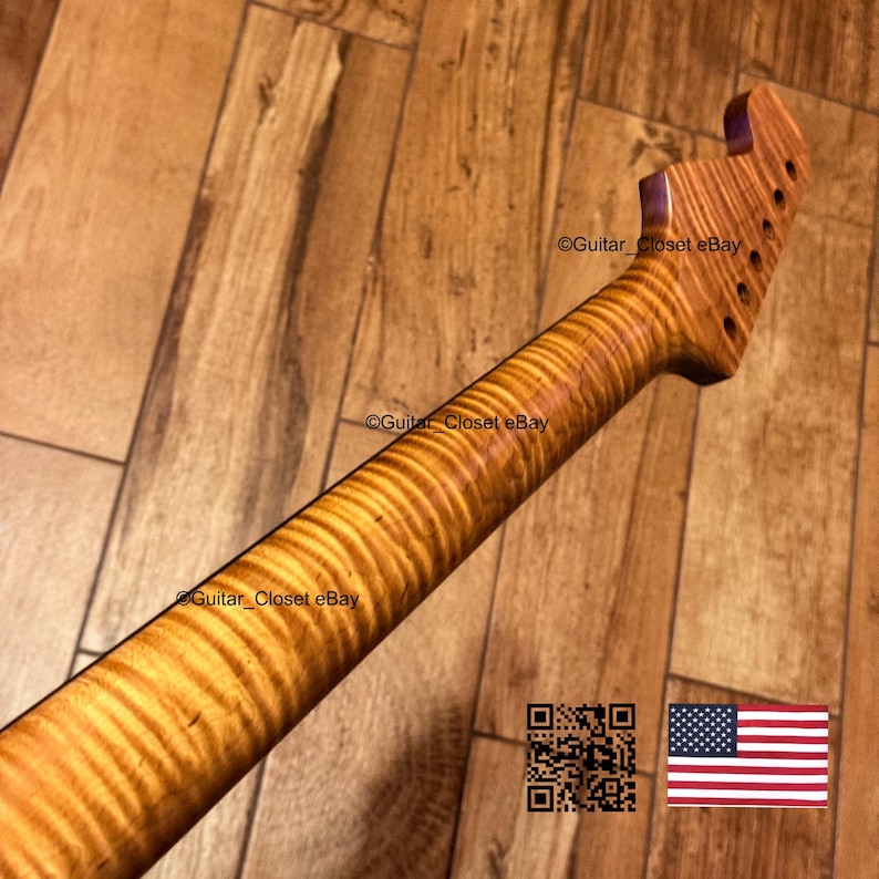 Puede incluir: Un m&aacute;stil de guitarra hecho de madera marr&oacute;n claro con un patr&oacute;n de veta flameada tipo tigre. El clavijero presenta seis orificios para las clavijas dispuestos en fila. El texto Guitar_Closet eBay es visible en el m&aacute;stil y el clavijero.