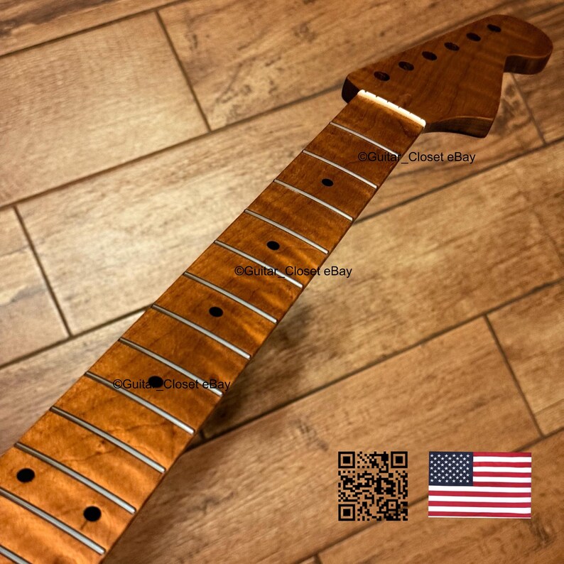 Puede incluir: Un m&aacute;stil de guitarra con un acabado de veta de madera en tonos &aacute;mbar c&aacute;lidos, con un clavijero prominente, trastes plateados y marcadores de traste circulares oscuros. La superficie muestra un patr&oacute;n de madera natural en toda su longitud.