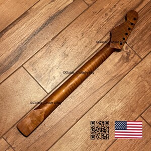 May include: A guitar neck crafted from brown flamed maple wood featuring a distinct tiger stripe grain pattern. The headstock includes six pre-drilled holes for tuning pegs. The text Guitar_Closet eBay is visible on the wood surface.