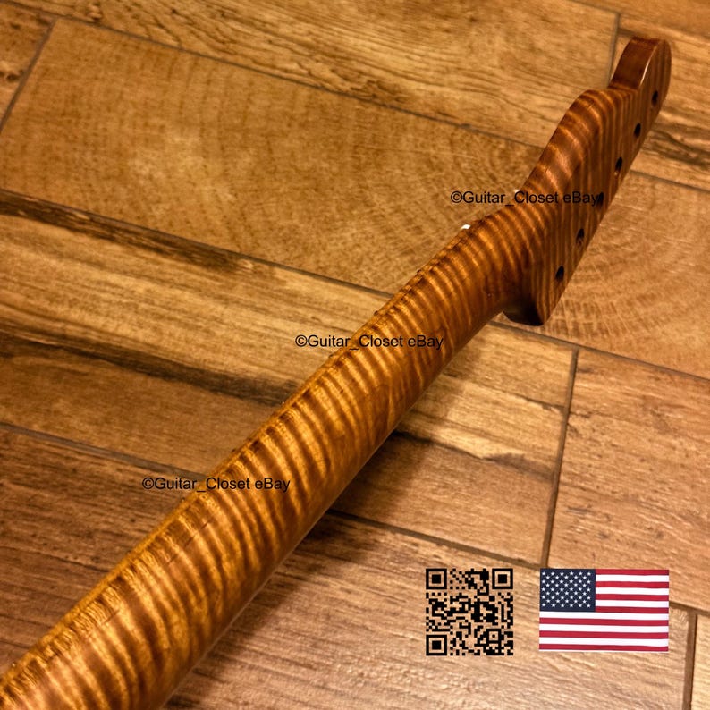 K&ouml;nnte beinhalten: Ein Gitarrenhals mit einer markanten Tigerstreifen-Flammenahorn-Holzmaserung und einem warmen bernsteinfarbenen Finish. Die Kopfplatte enth&auml;lt vorgebohrte L&ouml;cher f&uuml;r Stimmwirbel. Der Text Guitar_Closet eBay ist auf Hals und Kopfplatte sichtbar.