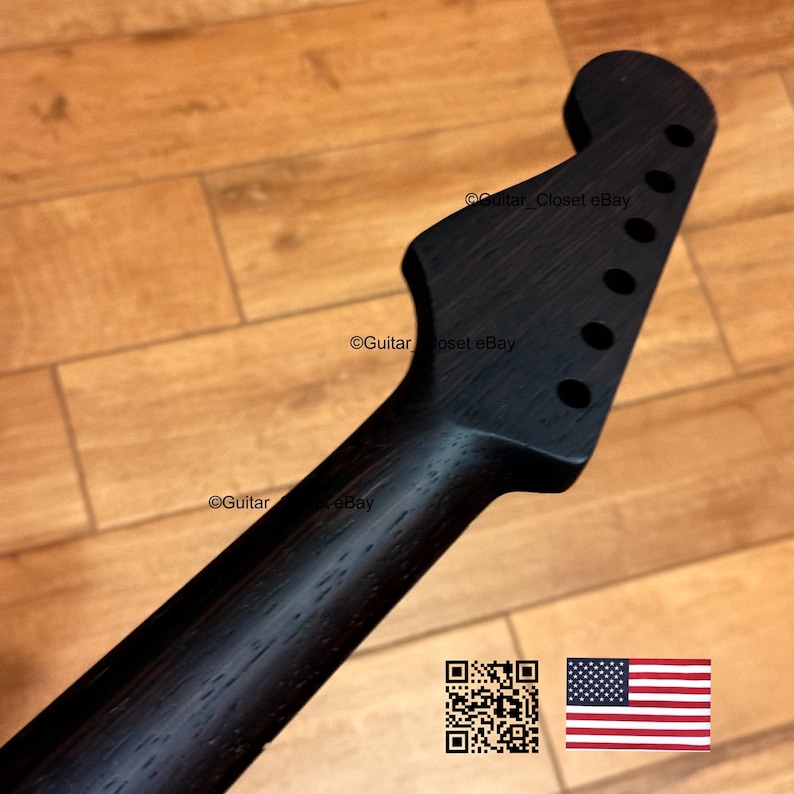 Peut inclure: Manche de guitare noir avec trous pour chevilles d'accord. La t&ecirc;te a une forme incurv&eacute;e. Le manche est en bois et a une finition lisse et sombre. L'image comprend un code QR et le drapeau am&eacute;ricain.