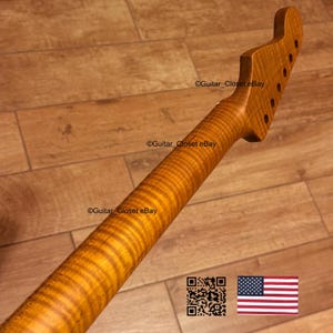 May include: A guitar neck made of figured maple, with a natural finish and a flamed pattern. The headstock has tuning peg holes. The image includes a QR code and the American flag. The neck is approximately 76 cm long.