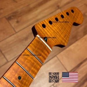 May include: A guitar neck with a flamed maple finish. The headstock has six tuning peg holes. The fretboard has silver frets and dark inlays. The text "Guitar_Closet eBay" is visible. An American flag and a QR code are in the lower right corner.
