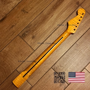 May include: A guitar neck with a flamed maple finish. The neck has a dark stripe down the center and is drilled for tuning pegs. The headstock has a classic shape, and the wood grain is visible. The image includes a QR code and a US flag.