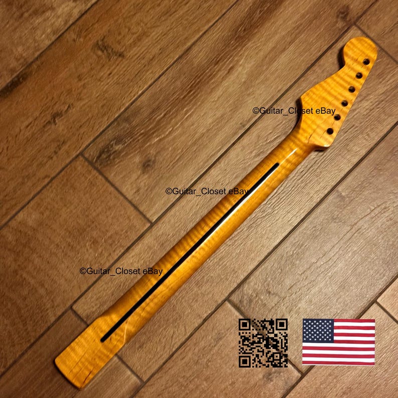May include: A guitar neck with a flamed maple finish. The neck has a dark stripe down the center and is drilled for tuning pegs. The headstock has a classic shape, and the wood grain is visible. The image includes a QR code and a US flag.