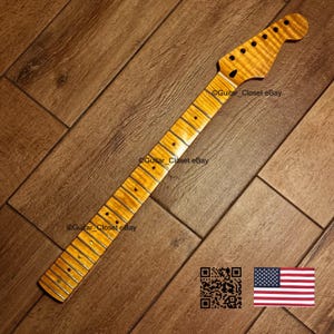May include: A guitar neck with a flamed maple finish. The neck has a headstock with tuning peg holes and a fretboard with inlaid position markers. The wood grain is visible. The image includes a QR code and an American flag.