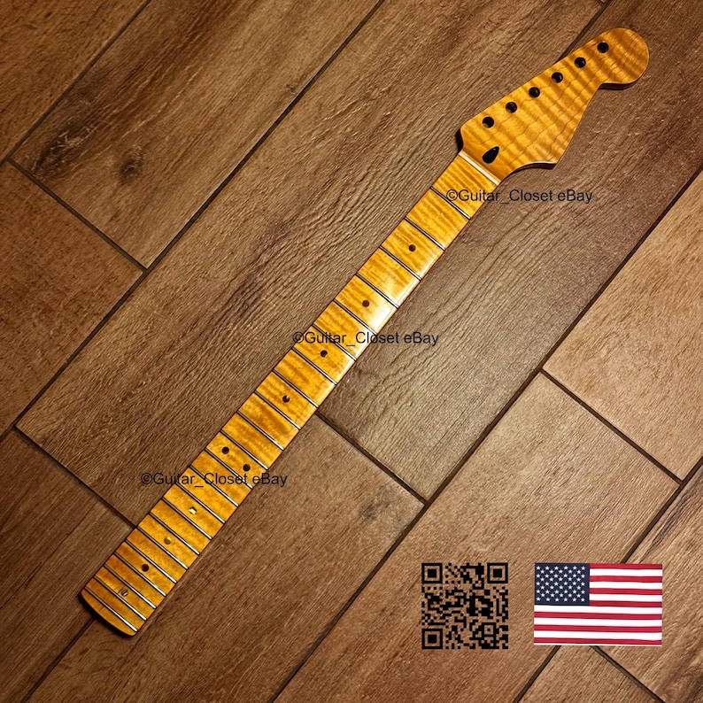 May include: A guitar neck with a flamed maple finish. The neck has a headstock with tuning peg holes and a fretboard with inlaid position markers. The wood grain is visible. The image includes a QR code and an American flag.