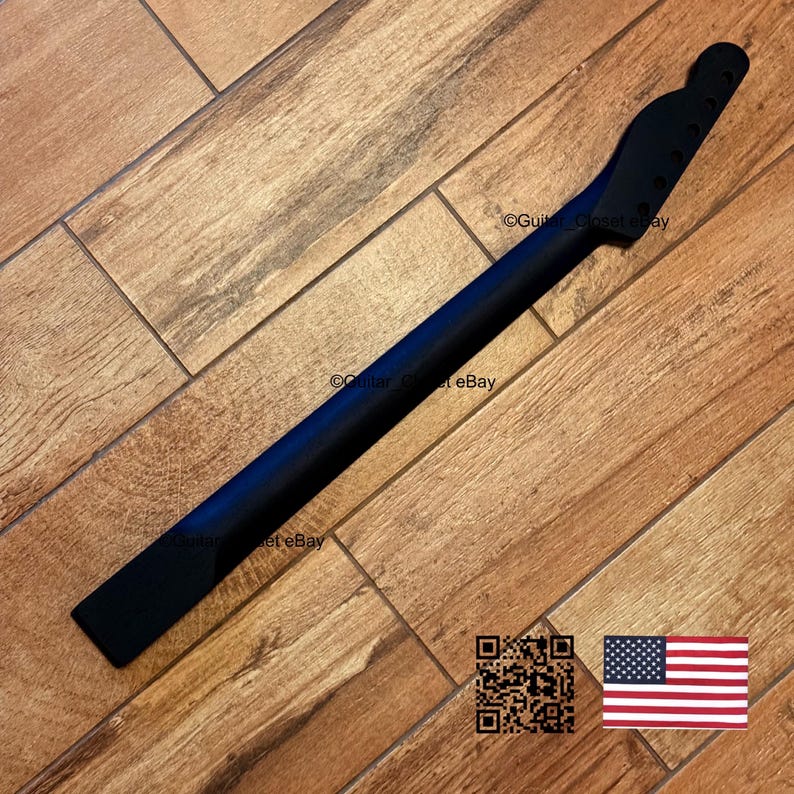 May include: A black guitar neck with a headstock, ready for assembly. The neck is made of wood and has a smooth, dark finish. The image is set against a wooden background.