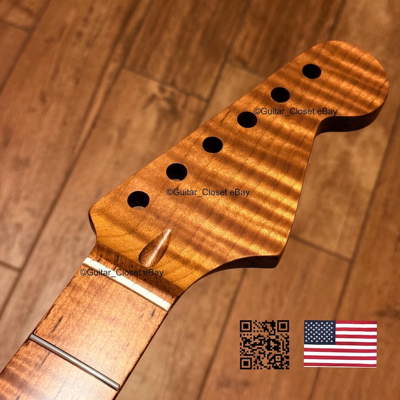 May include: A guitar headstock crafted from amber-toned flamed maple wood featuring a distinct wavy grain pattern, six tuner holes, and a white nut. The surface displays the text Guitar_Closet eBay, a QR code, and a small United States flag icon.