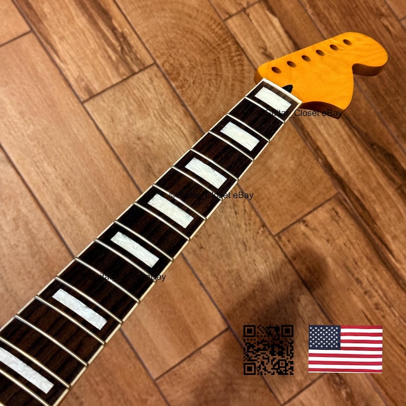 K&ouml;nnte beinhalten: Ein Gitarrenhals mit einer Kopfplatte aus Ahorn und einem dunkelbraunen Griffbrett mit wei&szlig;en Einlagen. Die Kopfplatte hat L&ouml;cher f&uuml;r die Stimmwirbel. Der Text "Closet eBay" ist sichtbar. Eine amerikanische Flagge befindet sich in der unteren rechten Ecke.