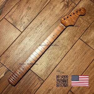 Puede incluir: Un m&aacute;stil de guitarra de arce flameado marr&oacute;n claro con un diapas&oacute;n liso, marcadores de posici&oacute;n circulares oscuros y trastes plateados. El clavijero incluye seis orificios preperforados. El texto Guitar_Closet eBay es visible en la madera.