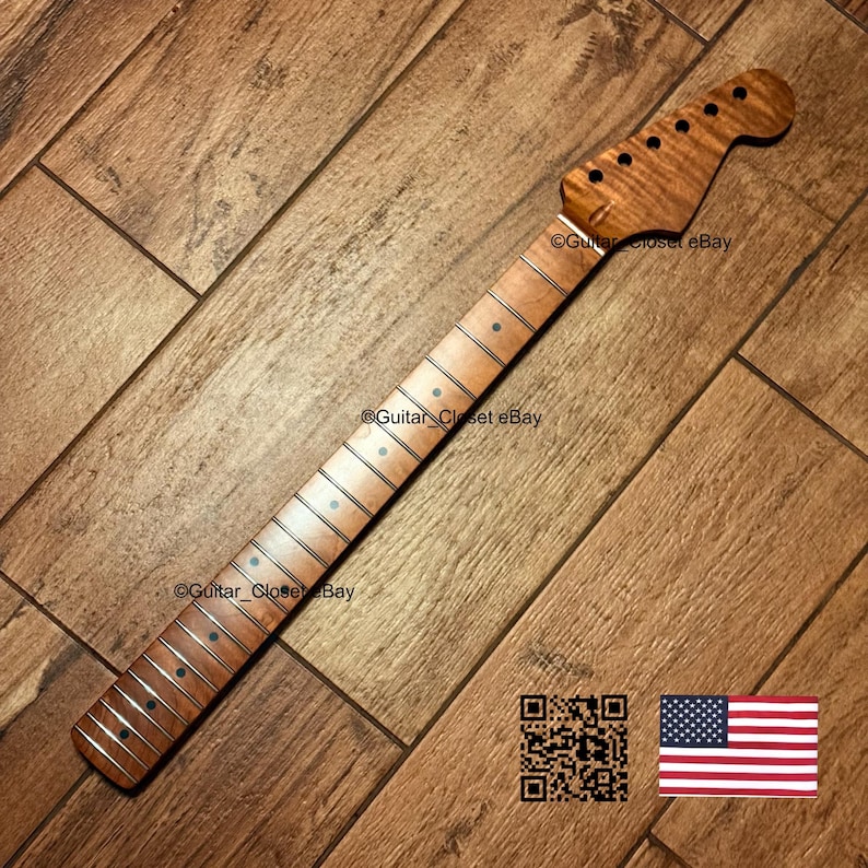 Puede incluir: Un m&aacute;stil de guitarra de arce flameado marr&oacute;n claro con un diapas&oacute;n liso, marcadores de posici&oacute;n circulares oscuros y trastes plateados. El clavijero incluye seis orificios preperforados. El texto Guitar_Closet eBay es visible en la madera.