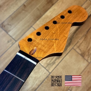 Puede incluir: Primer plano de un mástil y clavijero de guitarra. El clavijero es de color marrón claro con seis agujeros circulares para las clavijas. El diapasón es marrón oscuro con trastes plateados. El texto "Guitar_Closet eBay" es visible.