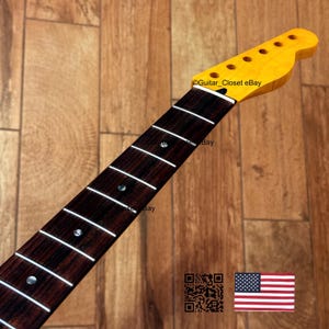 Puede incluir: M&aacute;stil de guitarra con pala amarilla y diapas&oacute;n marr&oacute;n oscuro. El diapas&oacute;n tiene trastes blancos y marcadores de traste plateados. El texto "Guitar Closet eBay" es visible en la pala. La bandera estadounidense est&aacute; en la esquina inferior derecha.