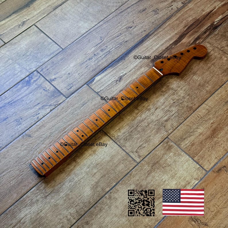 Puede incluir: Un m&aacute;stil de guitarra nuevo, sin terminar, hecho de madera marr&oacute;n claro. El m&aacute;stil tiene un clavijero con agujeros para las clavijas y un diapas&oacute;n con trastes met&aacute;licos. La veta de la madera es visible. La imagen incluye un c&oacute;digo QR y una bandera americana.
