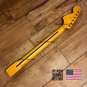K&ouml;nnte beinhalten: Ein Gitarrenhals aus Naturholz mit einem schwarzen Streifen in der Mitte. Die Kopfplatte hat sechs L&ouml;cher f&uuml;r die Stimmwirbel. Der Text "Guitar Closet eBay" ist sichtbar. Ein QR-Code und eine amerikanische Flagge sind im Bild.