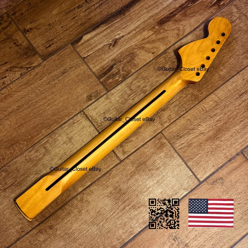K&ouml;nnte beinhalten: Ein Gitarrenhals aus Naturholz mit einem schwarzen Streifen in der Mitte. Die Kopfplatte hat sechs L&ouml;cher f&uuml;r die Stimmwirbel. Der Text "Guitar Closet eBay" ist sichtbar. Ein QR-Code und eine amerikanische Flagge sind im Bild.