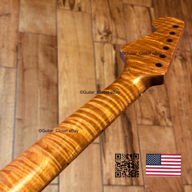 May include: A close-up of a guitar neck crafted from figured maple. The wood displays a unique grain pattern in warm, golden-brown tones. The headstock features tuning peg holes. The image includes the text "Guitar_Closet eBay" and a QR code.