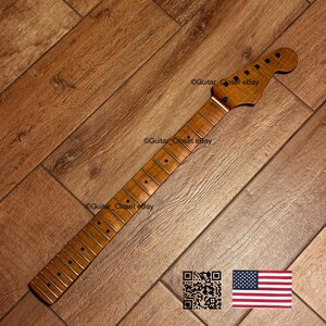 May include: A guitar neck with a natural wood finish. The neck has a headstock with tuning peg holes and a fretboard with inlaid position markers. The image includes a QR code and an American flag.
