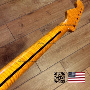 May include: Close-up of a guitar neck with a flamed maple finish. The neck has a dark stripe down the center and a headstock with tuning peg holes. The image includes a QR code and the American flag.