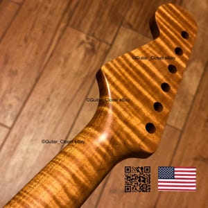 May include: A guitar neck featuring a headstock with six tuner holes, crafted from light brown wood with a prominent tiger-stripe flame maple grain pattern. The text Guitar_Closet eBay is visible on the wood surface, alongside a QR code and a US flag.