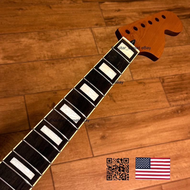 May include: A guitar neck with a brown headstock and a black fretboard with white inlays. The neck is angled towards the bottom right, with the headstock at the top. The text "guitar_set eBay" is visible. An American flag is in the bottom right.