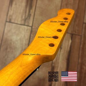 Puede incluir: Primer plano de un m&aacute;stil de guitarra con acabado de madera natural. El clavijero tiene seis agujeros para las clavijas y el texto "Guitar_Closet eBay". La bandera americana est&aacute; en la esquina inferior derecha.