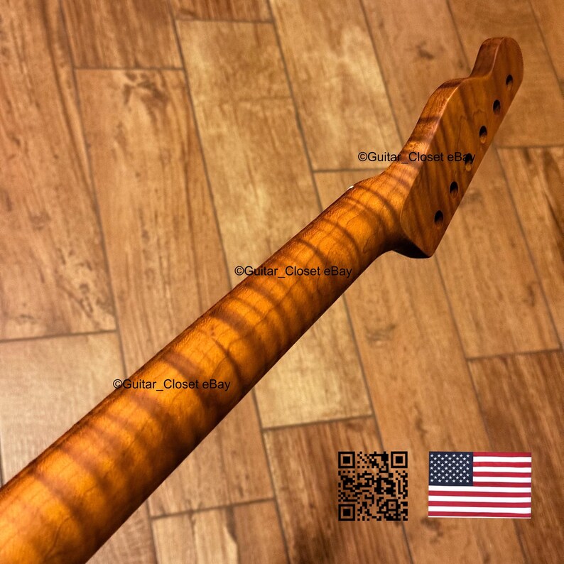 May include: A close-up of a guitar neck made of figured wood, showcasing a natural wood grain pattern. The neck has a headstock with pre-drilled holes for tuning pegs. The wood has a warm, amber hue. The text "Guitar Closet eBay" is visible.