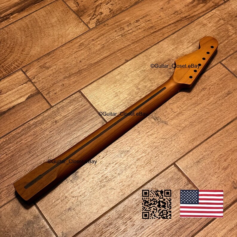 Puede incluir: Un m&aacute;stil de guitarra de madera natural con una franja oscura en el centro de la parte posterior, un clavijero con seis orificios preperforados para las clavijas y un acabado liso. El texto Guitar_Closet eBay es visible en la madera.