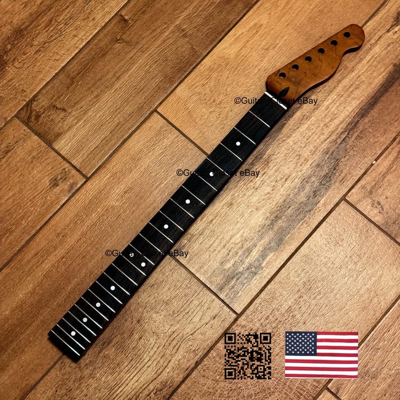 May include: A guitar neck with a dark fretboard and a light-colored headstock. The fretboard has white dot inlays. The headstock is a lighter brown color. The neck is set against a wooden background. The image includes a QR code and an American flag.