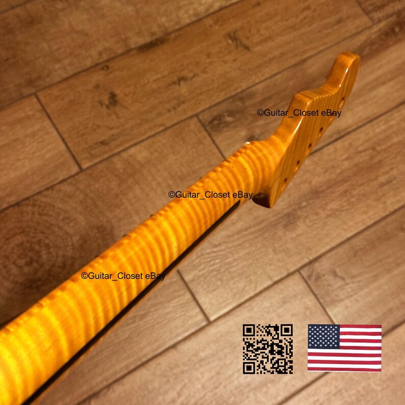 May include: A maple guitar neck with a flamed grain pattern. The neck is a light amber color and has a smooth, polished finish. The headstock has tuning peg holes. The image also includes a QR code and the American flag.