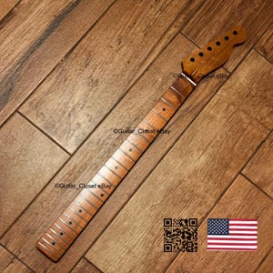 May include: A light brown wooden guitar neck featuring a smooth fretboard with dark circular position markers, silver metal frets, and a headstock with six tuner holes. The text Guitar_Closet eBay is visible on the wood surface.