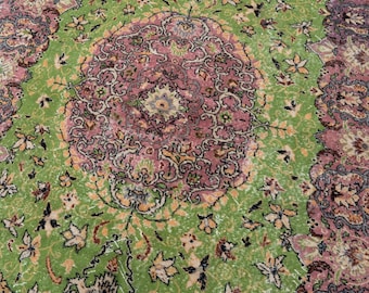 May include: A rectangular area rug featuring a vibrant lime green central field adorned with a large, intricate pink and dark purple floral medallion. The border displays a repeating pattern of ornate pink and purple floral motifs.