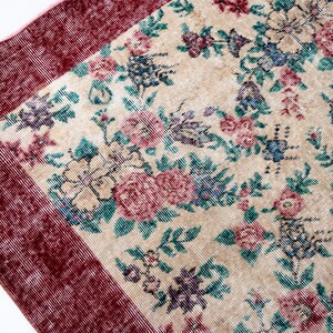 Pode incluir: Um tapete de estilo vintage com um campo central creme, adornado com um padr&atilde;o floral em tons de rosa, azul e roxo. O tapete tem uma borda bord&ocirc; escura, adicionando uma moldura contrastante ao design. Adequado para decora&ccedil;&atilde;o de casa.